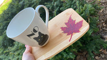 Load image into Gallery viewer, Pre-treated bamboo mini serving tray is small enough for two kids hands or one adult hand for coffee! The Canadian maple leaf has been hand carved and filled with red epoxy. Each pieces is treated with Walrus Oil Food-safe Cutting board oil. 
